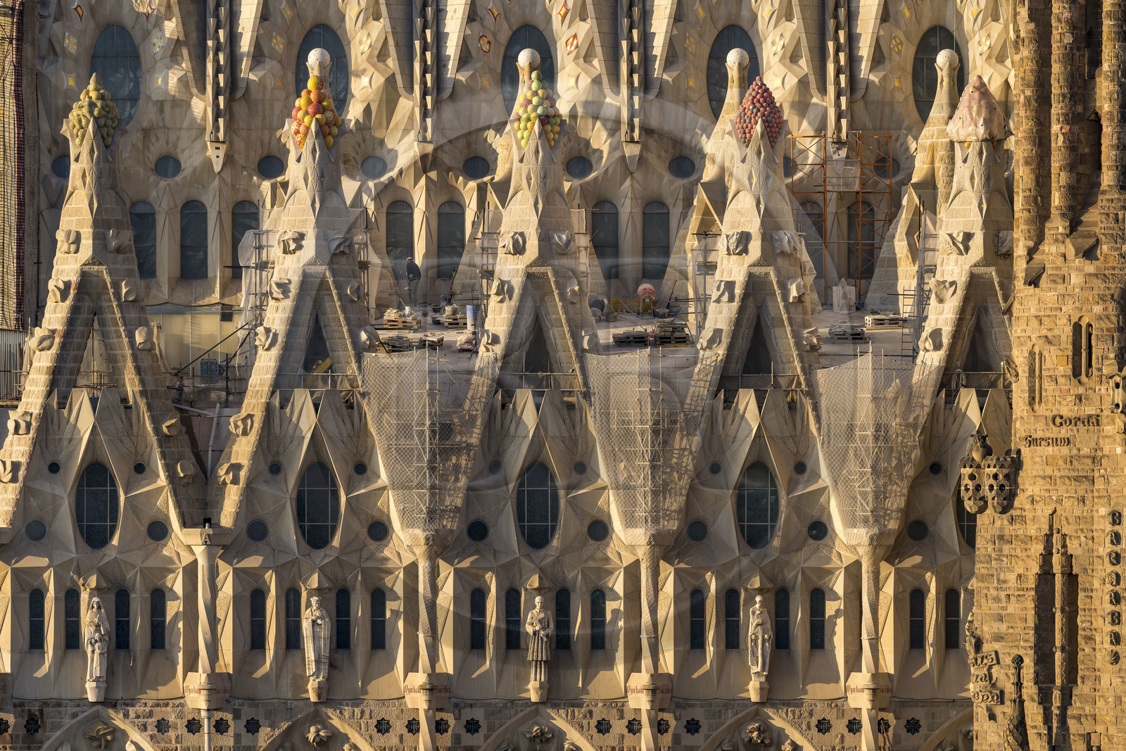 Espagne, Catalogne, Barcelone, quartier de l'Eixample, basilique de la Sagrada Familia de l'architecte du modernisme catalan Antoni Gaudi classée Patrimoine Mondial de l'UNESCO, sommets surmontés de mosaïques en forme de fruits entourant le chantier sur le toit de la nef ici côté facade de la Passion