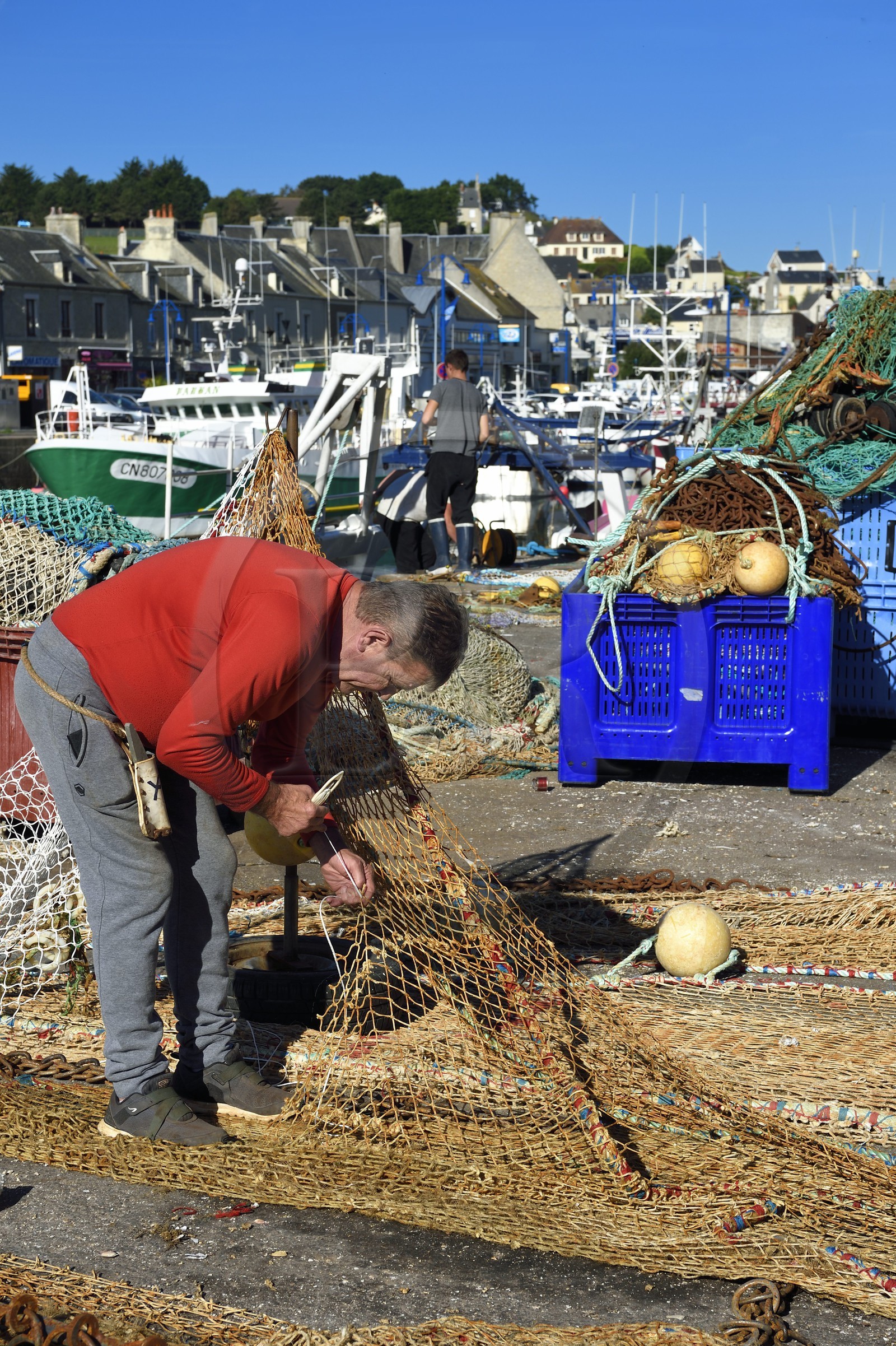 France, Calvados (14), Cote de Nacre, Port-en-Bessin, le port de pêche, pecheur réparant des filets