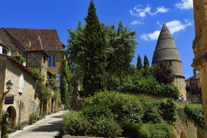 France, Dordogne (24), Périgord Noir, vallée de la Dordogne, Sarlat-la-Canéda, vieille maison au pigeonnier dans la rue Montaigne à gauche et La Lanterne des morts (XIIème siècle) de près de 10 m de haut à droite
