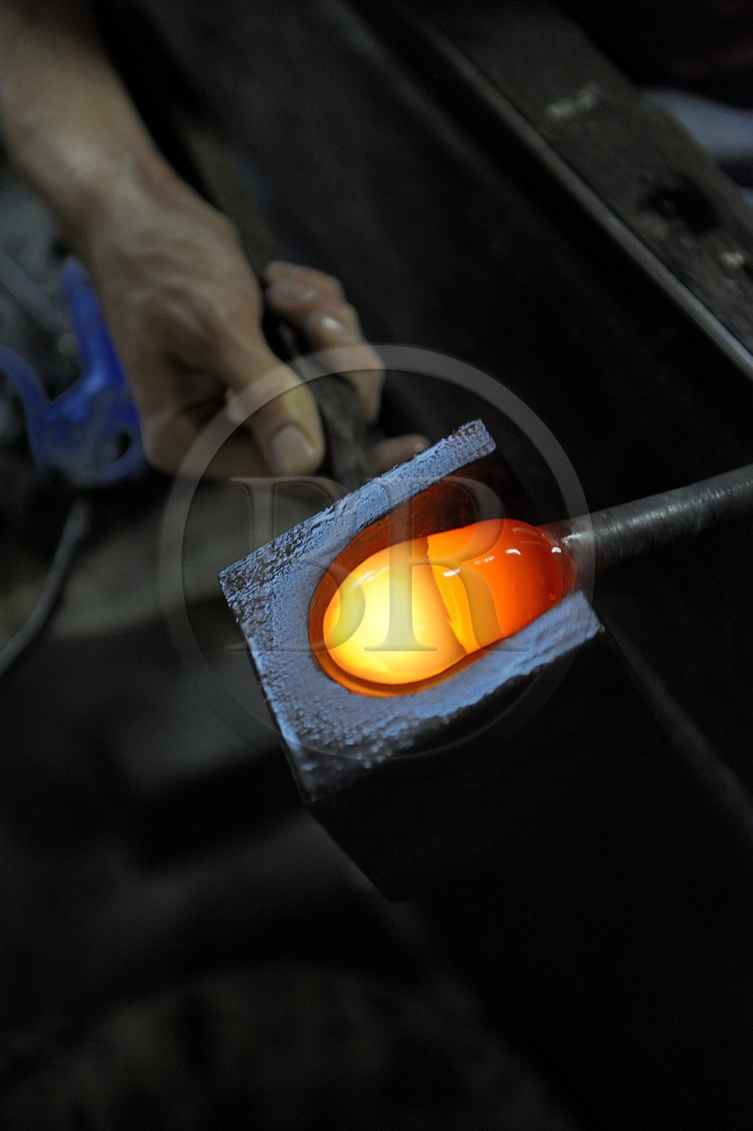 France, Moselle (57), Meisenthal, Thibaut souffleur au Centre international d’Art verrier (CIAV) s’aide d’une mailloche en bois pour arrondir le verre et faire une boule de Noël en verre régulière