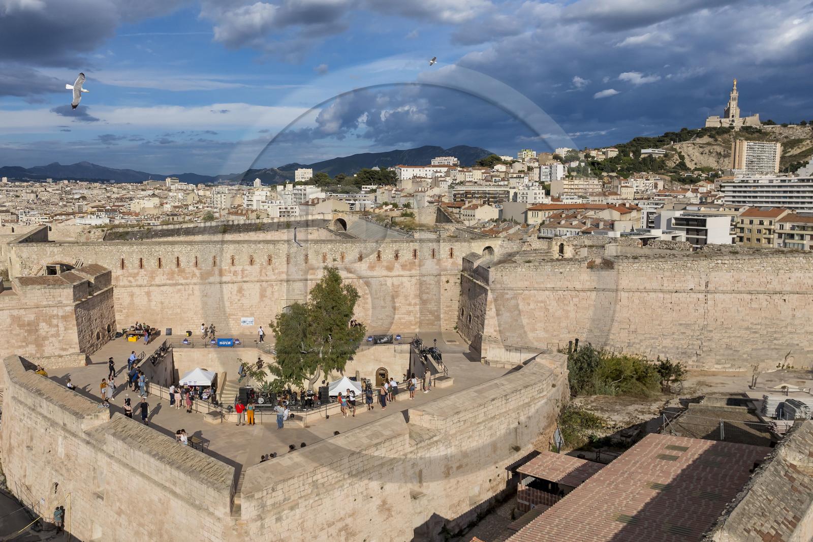France, Bouches-du-Rhône (13), Marseille, Citadelle de Marseille (Fort Saint-Nicolas, le haut fort appelé fort d’Entrecasteaux) et la basilique Notre Dame de la Garde en arrière plan, concert dans la partie haute pendant le Au Large Festival (vue aérienne)