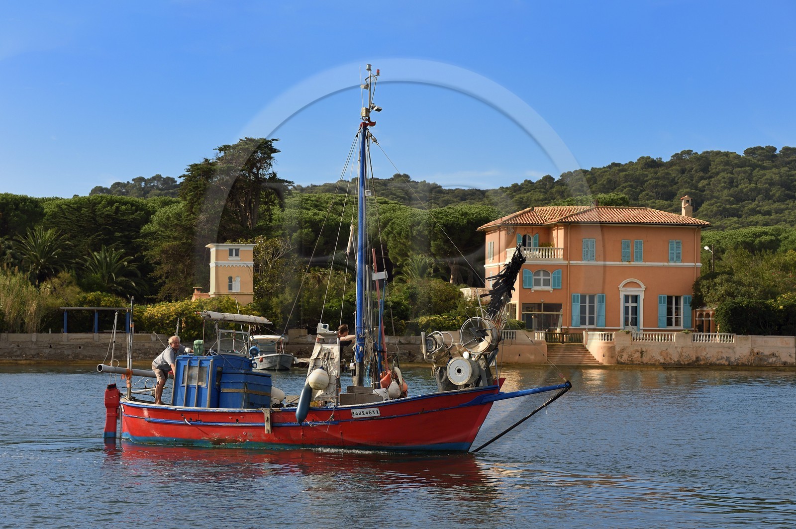 France, Var (83), Iles d'Hyères, parc national de Port Cros, Ile de Porquerolles, Bernard Samuel dit Sam le pêcheur sur son pointu (bateau) Le Corailleur, la demeure historique de François-Joseph Fournier en arrière plan