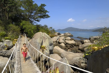 Brazil, Rio de Janeiro State, Paraty, Catimbau island, Thomas Campers running on the footbridge between the two islands