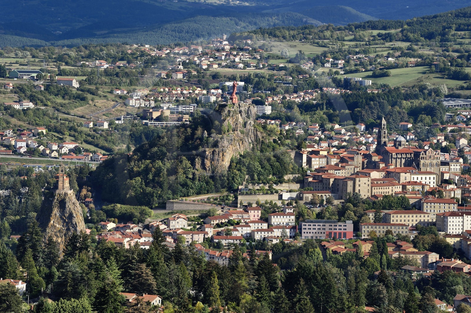 France, Haute-Loire (43), Le Puy-en-Velay, étape classée Patrimoine Mondial de l'UNESCO dans le cadre des chemins de Compostelle, vue sur la ville avec la Chapelle Saint-Michel d'Aiguilhe perchée sur un piton volcanique à gauche, la statue Notre Dame de France (de 1860) sur le Rocher Corneille surplombant la cathédrale Notre Dame de l'Annonciation du XIIe siècle à droite