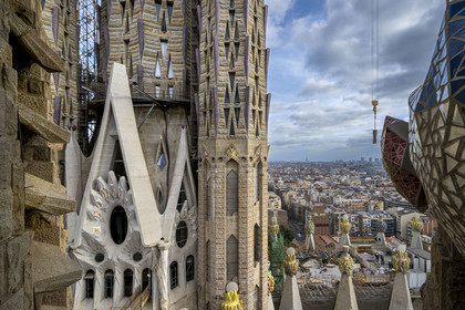 Espagne, Catalogne, Barcelone, quartier de l'Eixample, basilique de la Sagrada Familia de l'architecte du modernisme catalan Antoni Gaudi classée Patrimoine Mondial de l'UNESCO, la tour centrale et sommets surmontés de mosaïques en forme de fruits entourant le chantier sur le toit de la nef à l'arrière de la future facade de la Gloire