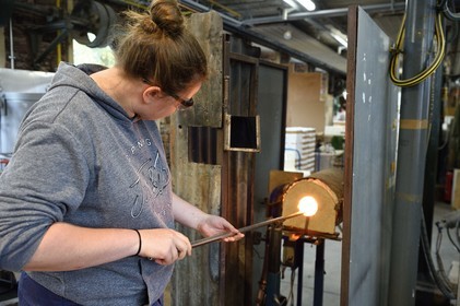 France, Moselle (57), Meisenthal, Centre international d’Art verrier (CIAV), l'atelier de soufflage, fabrication artisanale d'une boule de Noël, le souffleur recueille dans le four une masse de verre en fusion avec sa canne de verrier