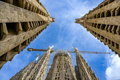 Espagne, Catalogne, Barcelone, quartier de l'Eixample, basilique de la Sagrada Familia de l'architecte du modernisme catalan Antoni Gaudi classée Patrimoine Mondial de l'UNESCO, deux des quatre campaniles de 135m entourant le ciborium central et la future tour centrale, le pinacle est couronné par le lion ailé qui symbolise saint Marc et un homme ailé pour saint Matthieu, au premier plan les pinacles des tours de la façade de la Passion, le récemment achevé sommet de la tour de Marie avec l'étoile de la vierge lumineuse sur la gauche