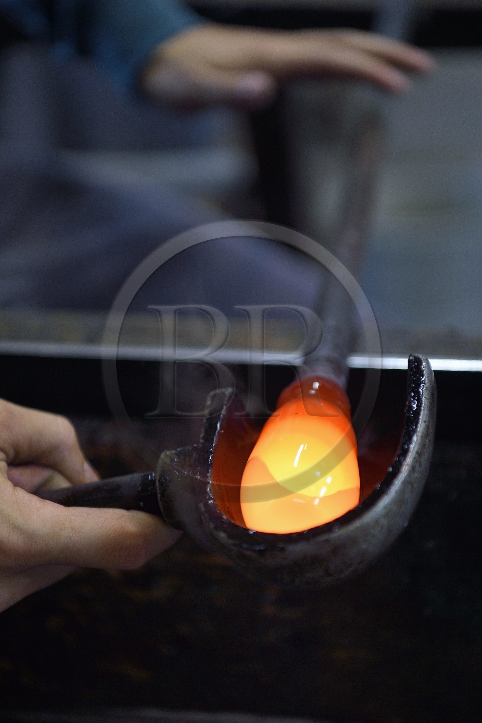 France, Moselle (57), Meisenthal, Centre international d’Art verrier (CIAV), l'atelier de soufflage, fabrication artisanale d'une boule de Noël, le souffleur régularise la masse au marbre tout en effectuant une rotation continue de sa canne