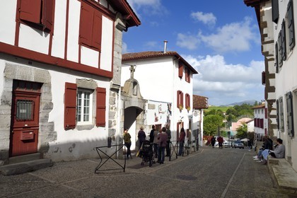 France, Pyrenees Atlantiques, Basque Country, Espelette, traditional house with carved lintel dating from 1663 and the entrance to Saint-Etienne Elementary School