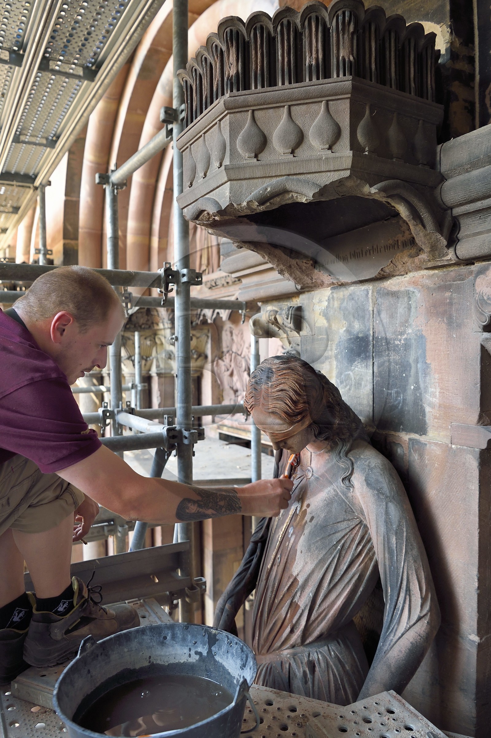 France, Bas-Rhin (67), Strasbourg, vieille ville classée au Patrimoine Mondial de l'UNESCO, la cathédrale Notre-Dame, chantier de restauration du Portail du Jour du jugement, nettoyage de la sculpture dite de la Synagogue à la brosse à dent par un compagnon tailleur de pierre