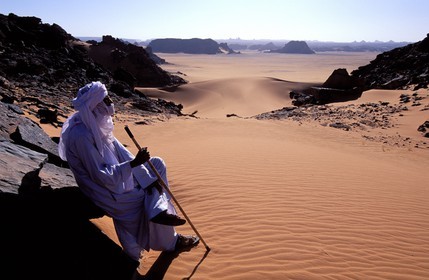 Libya, region of the desert, the Fezzan (Sahara), Tadrart Akacus, Tuareg walking in the middle of the ruins