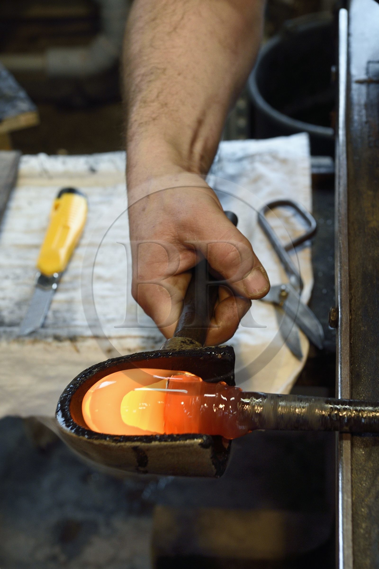 France, Moselle (57), Meisenthal, Centre international d’Art verrier (CIAV), l'atelier de soufflage, fabrication artisanale d'une boule de Noël, le souffleur régularise la masse au marbre tout en effectuant une rotation continue de sa canne
