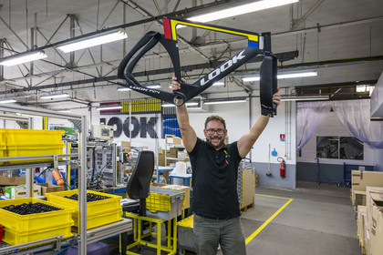 France, Nièvre (58), Nevers, entreprise Look Cycles International, le technicien site évenementiel Thomas Millot brandit le cadre du vélo de compétition en carbone ultra-léger LOOK P24 qui a permis à Benjamin Thomas de gagner la médaille d'or aux JO de Paris 2024