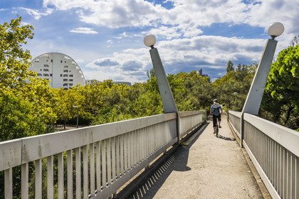 France, Herault, La Grande-Motte, labeled 20th century heritage, Couchant (setting sun) district west of the port, cyclist crossing the so-called footbridge of the Monsters
