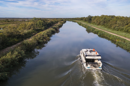 France, Gard (30), la Petite Camargue, navigation d'un bateau de plaisance Le Boat sur le canal du Rhône à Sète entre Gallician et Aigues-Mortes (vue aérienne) France, Gard, the Petite Camargue, navigation of a pleasure boat Le Boat on the Rhone to Sète Canal between Gallician and Aigues-Mortes (aerial view)