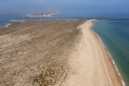 Portugal, Algarve, Ria Formosa Natural Park, Faro, Island of Barreta or Deserta (Ilha da Barretta or Deserta), the lighthouse of Ilha do Farol part of  Ilha da Culatra in the background (aerial view)