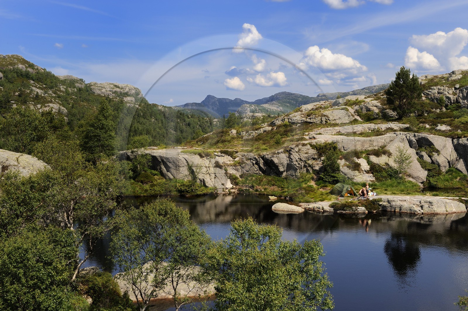 Norvège, Rogaland, région du Lysefjord, campeurs au bord d'un petit lac sur le chemin de randonnée menant au Rocher de La Chaire (Preikestolen)