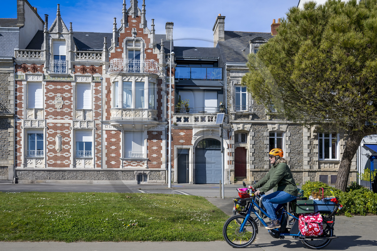 France, Loire-Atlantique (44), Saint-Nazaire, boulevard du Président Wilson sur le front de mer, cycliste utilisant un Velycéo avec son chien passant devant une des maisons épargnées par les bombardements de la deuxième guerre mondiale