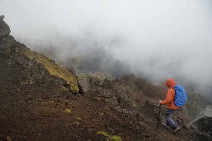 Italie, Sicile, Parc naturel régional de l’Etna, le Mont Etna, classé Patrimoine Mondial de l'UNESCO, randonneurs en bordure de la Valle del Bove qui correspond à un effondrement d’une des parois de l’Etna créant un champ de roches volcaniques de 7 km par 6 km