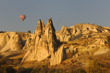 Turkey, Central Anatolia, Nevsehir Province, Cappadocia listed as World Heritage by UNESCO, hot air baloon flying over an eroded landscape and fairy chimneys near Uchisar and Goreme