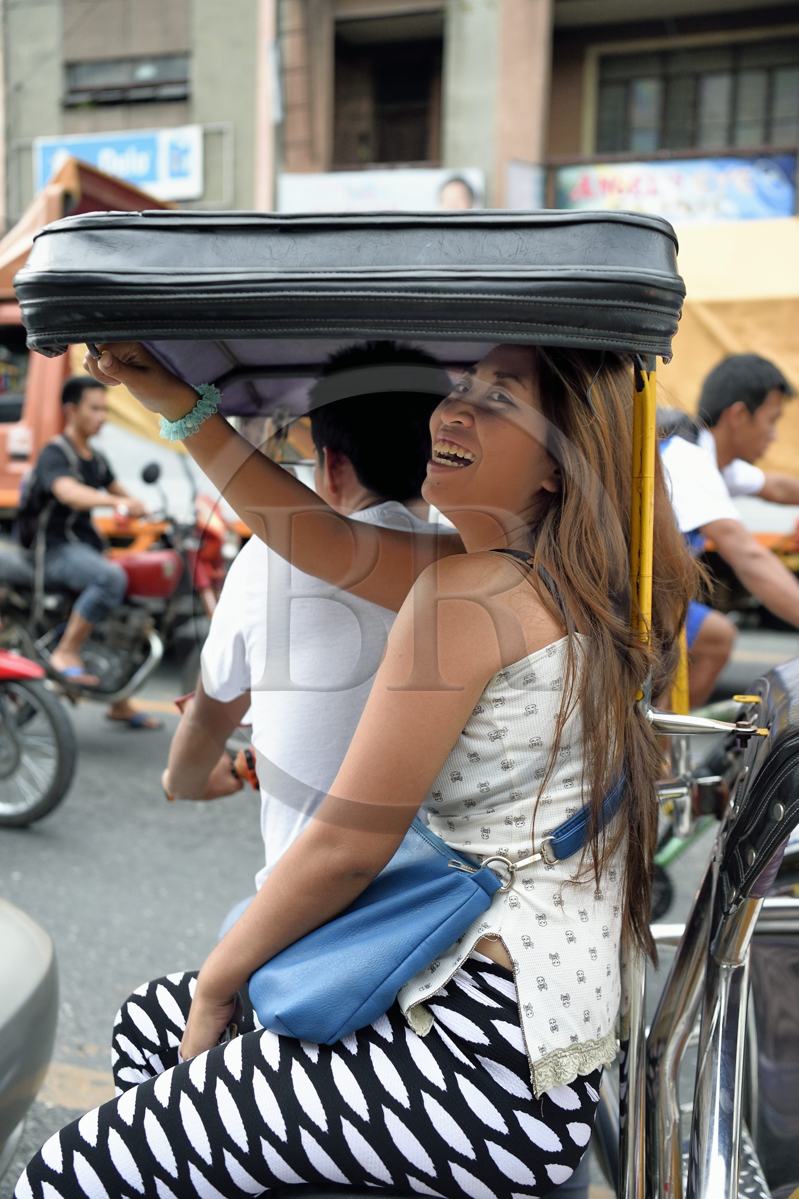 Philippines, province de Nueva Ecija, Bambang, femme à l'arrière d'un tricycle moto-taxi dans la rue principale