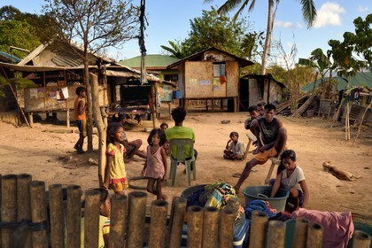 Philippines, Calamian Islands dans le nord de Palawan, Uson Island dans la baie de Coron, village de Barangay Lajala, le pêcheur Tagbanua Carlito Bering entouré de sa famille dans la cour de sa maison