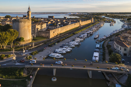 France, Gard (30), Aigues-Mortes, la ville médiévale entourée par ses remparts, la Tour de Constance et le port du canal du Rhône à Sète au premier plan, les marais salants (Salins du Midi) en arrière plan (vue aérienne)