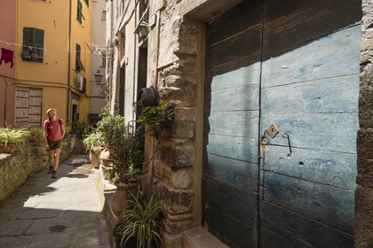 Italy, Liguria, Cinque Terre National Park listed as World Heritage by UNESCO, hiker crossing the village of Vernazza