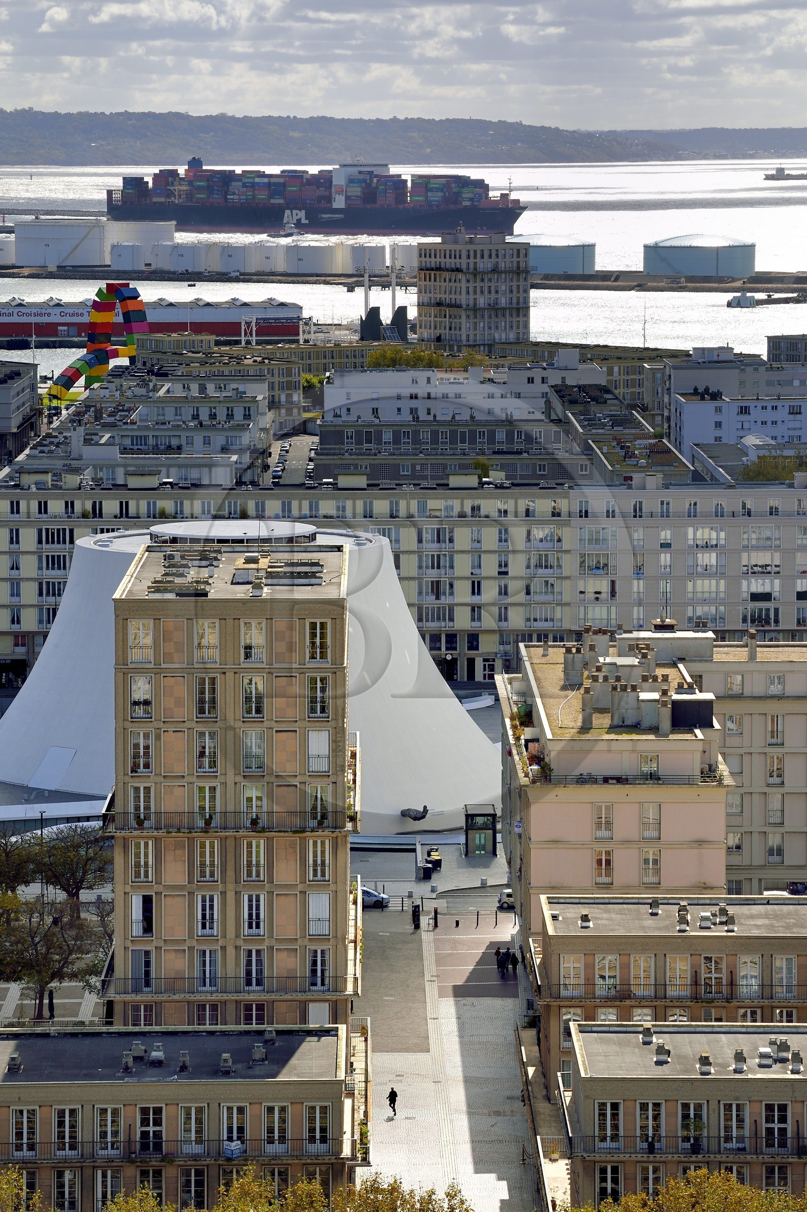 France, Seine-Maritime (76), Le Havre, Centre-ville reconstruit du Havre par Auguste Perret classé Patrimoine Mondial de l'UNESCO, immeubles Perret autour du Volcan réalisé par Oscar Niemeyer, un porte-conteneurs en arrière plan sort du port de commerce France, Seine-Maritime (76), Le Havre, Centre-ville reconstruit du Havre par Auguste Perret classé Patrimoine Mondial de l'UNESCO, immeubles Perret autour du Volcan réalisé par Oscar Niemeyer, un porte-conteneurs en arrière plan sort du port de commerce