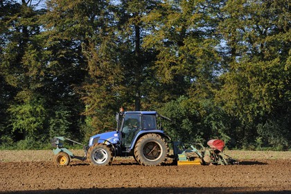 France, Seine Maritime, Varengeville sur Mer, plowing a field near the forest