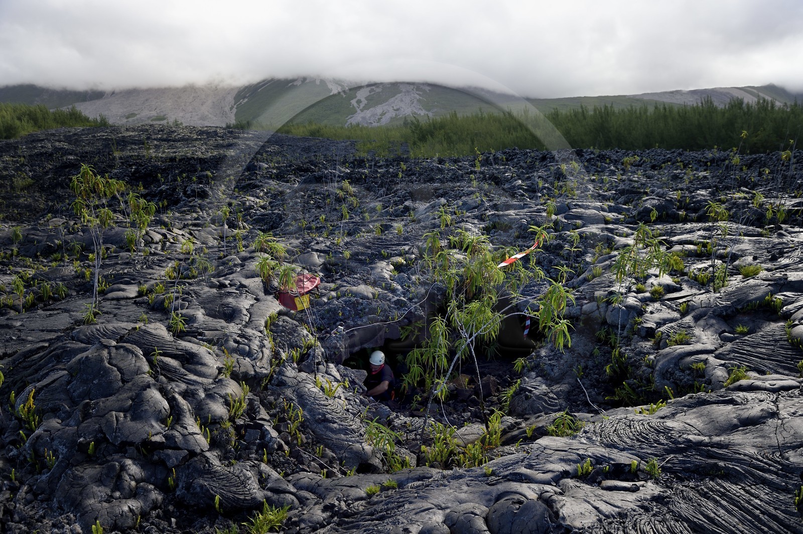 France, Ile de la Reunion, volcan du Piton de la Fournaise, classé Patrimoine Mondial de l'UNESCO, le Grand-Brûlé, coulée de lave récente au pied du volcan, pompier à l'entrée d'un tunnel de lave à l'occasion d'un exercice de sauvetage