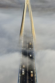 France, between  Calvados and Seine Maritime, the Pont de Normandie (Normandy Bridge) that emerges from the morning mist of autumn and spans the Seine, view from the top of the south pylon
