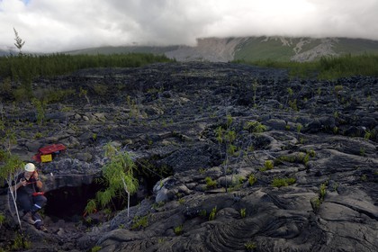 France, Ile de la Reunion, volcan du Piton de la Fournaise, classé Patrimoine Mondial de l'UNESCO, le Grand-Brûlé, coulée de lave récente au pied du volcan, pompier à l'entrée d'un tunnel de lave à l'occasion d'un exercice de sauvetage