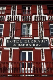 France, Pyrenees Atlantiques, Basque Country, Espelette, drying of Espelette peppers on the facades of village houses, the Euzkadi Hotel