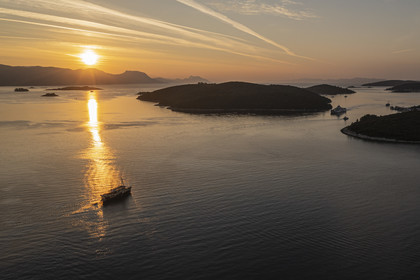Croatie, Dalmatie, cote dalmate, bateau naviguant à l'aube vers l'archipel de Skoji dans le détroit entre la presqu'ile de Peljesac et Ile de Korcula (vue aérienne)