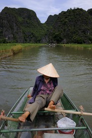 Vietnam, province de Ninh Binh, région surnommée la baie d'Halong terrestre, excursion en barque à Tam Coc entouré de montagnes karstiques , ramant avec ses pieds