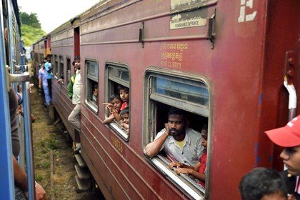 Sri Lanka, Central Province, the popular scenic train ride through the tea growing hill country between Hatton and Badulla, Great Western train station, passengers hanging on the door