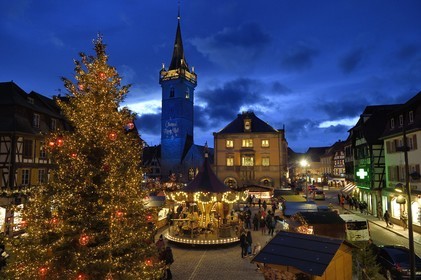 France, Bas Rhin, Obernai, Christmas market on the market square, Chapel Tower (Kappelturm) completed in the 16th century, serves as a belfry next to the town hall