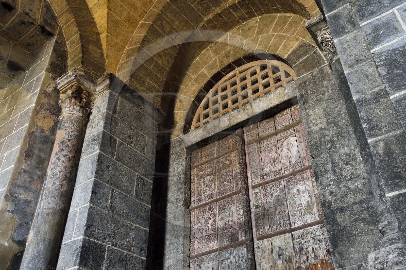 France, Haute-Loire (43), Le Puy-en-Velay, étape des chemins de Compostelle, porche de la cathédrale Notre-Dame-de-l'Annonciation du XIIe siècle classée Patrimoine Mondial de l'UNESCO, chapelle Saint Gilles latérale souterraine sous le porche, portes dites de cèdre en bois sculpté du XIIe siècle représentant des épisodes de la vie du Christ