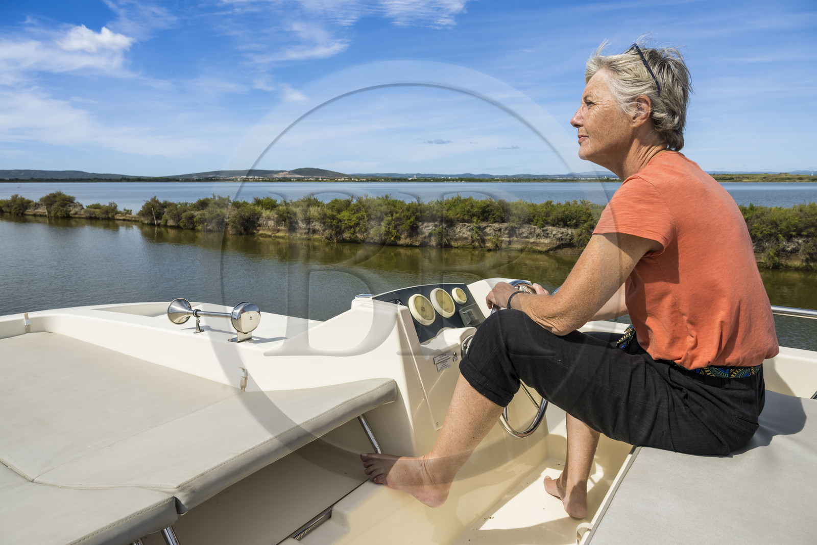 France, Hérault (34), Villeneuve-lès-Maguelone, navigation d'un bateau de plaisance Le Boat sur le canal du Rhône à Sète en bordure de l'étang l'Arnel en arrière plan