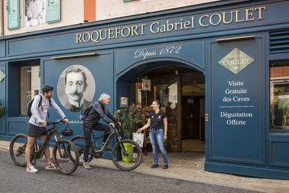 France, Aveyron, Grands-Causses Regional Nature Park, Roquefort sur Soulzon, cyclists on the Brebis Cyclette tourist cycle route in the Pays de Roquefort, head office and shop of the Gabriel Coulet Roquefort cheese maturing cellar