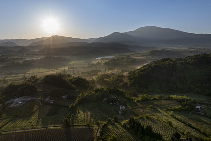 France, Vaucluse, Dentelles de Montmirail mountains, Crestet, the plain north of Malaucène at sunrise and Mont Ventoux in the background (aerial view)