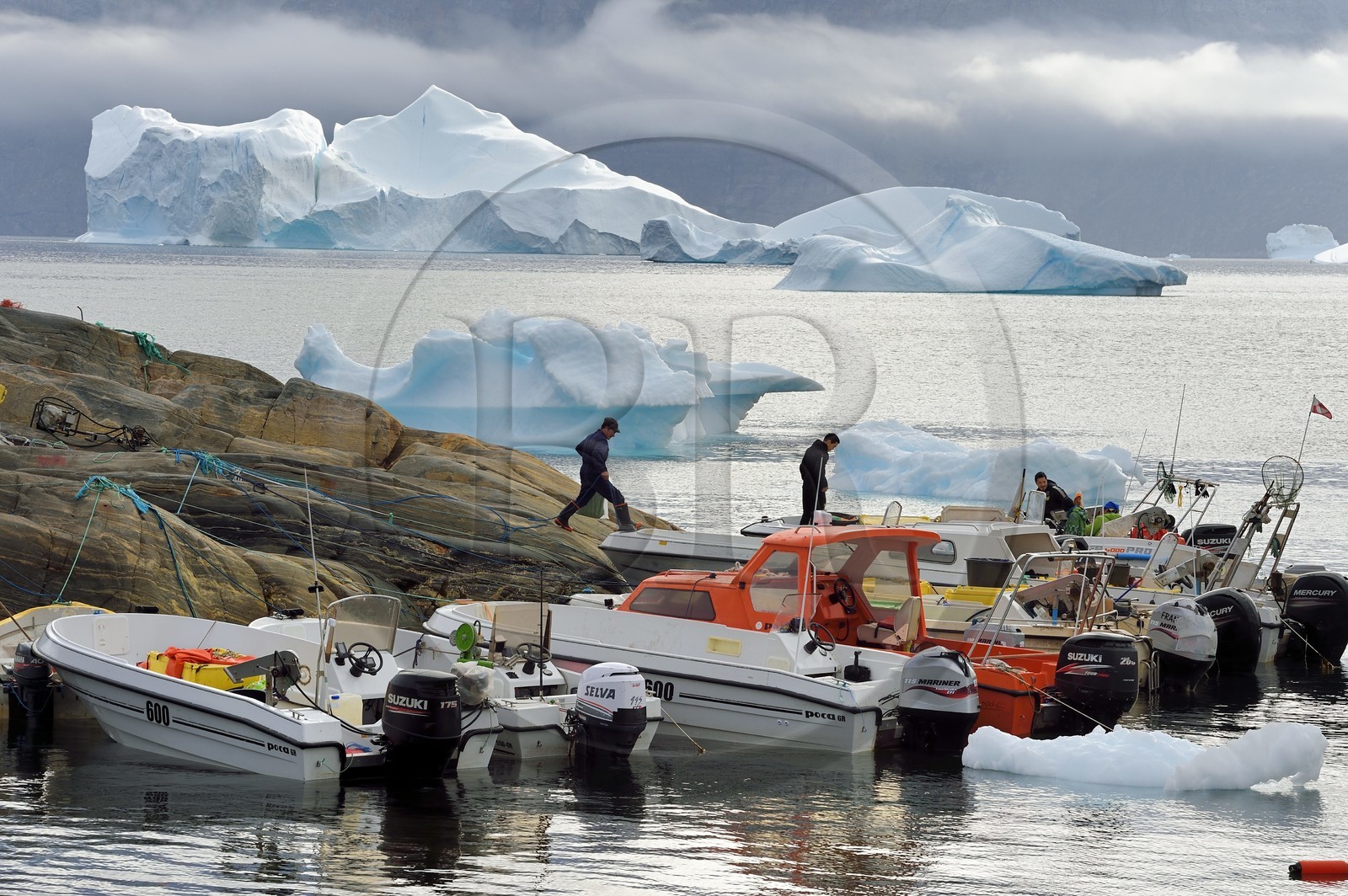 Groenland, cote ouest, fjord de Uummannaq, bateaux pour la pêche et la chasse, icebergs à la sortie du port