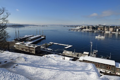 Norvège, Oslo, le fjord, le port et les quais de Pipervika vue de la colline d'Akershus sous la neige, le quartier d'Aker Brygge en arrière plan à droite
