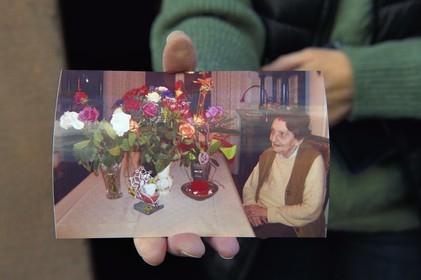 France, Bas-Rhin (67), Schiltigheim, Geneviève Zaehringer tient la photo de sa tante centenaire aujourdhui décédée à qui appartenait la fontaine au radium, verre d'eau dans lequel on faisait infuser une porcelaine irradiée au radium