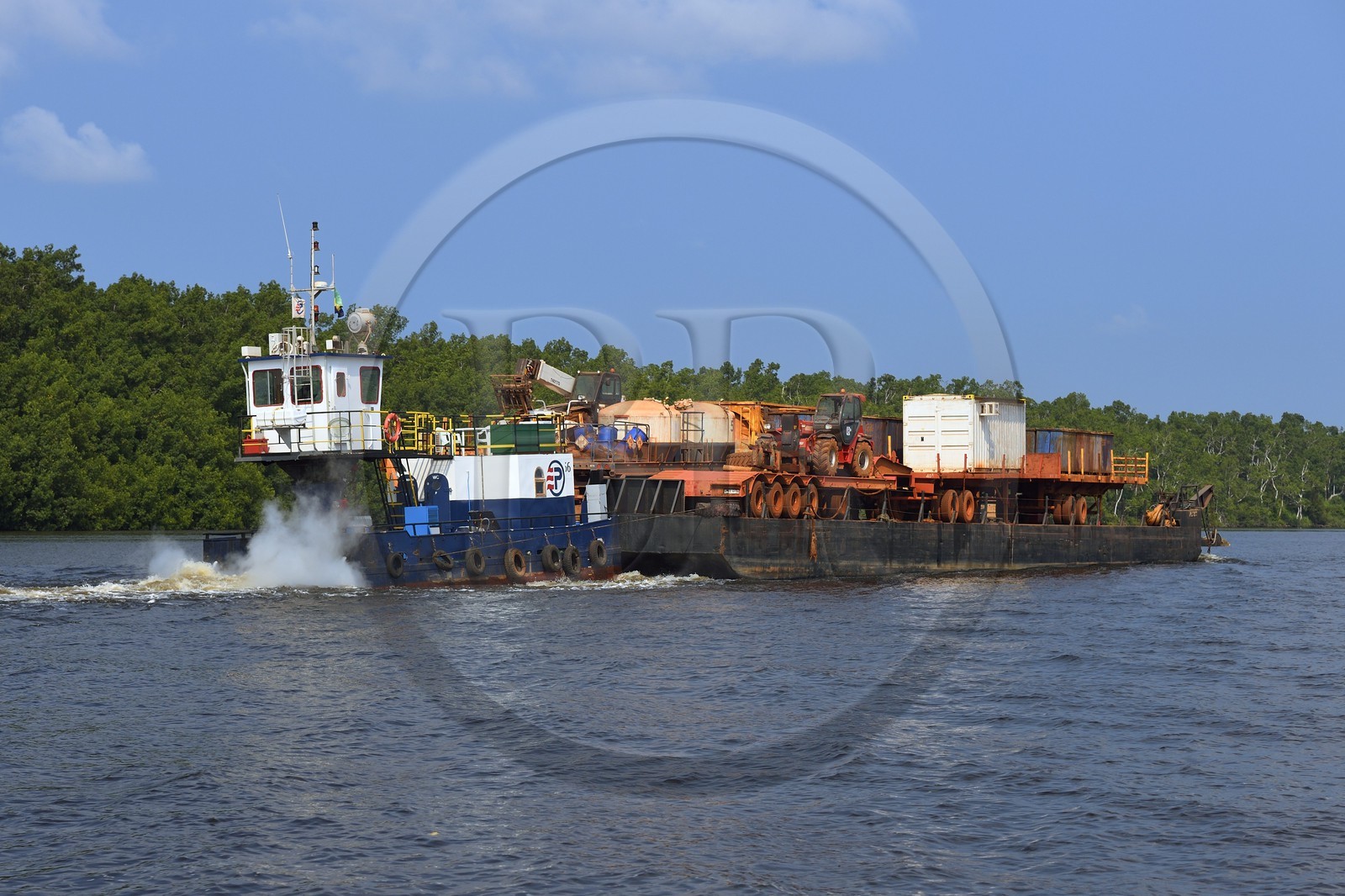 Gabon, province de Ogooué- Maritime, région de Port-Gentil, bateau poussant une barge d'engins de terrassement sur une rivière débouchant sur la baie du Cap Lopez, le manque de routes est compensé par l'utilisation des rivières