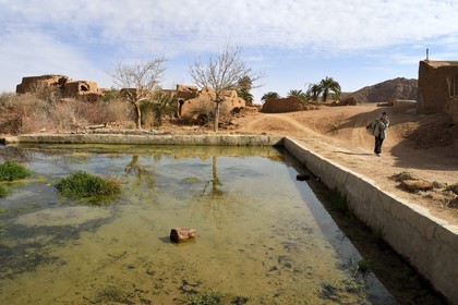 Iran, Province d'Ispahan, désert du Dasht-e Kavir, l'oasis d'Arousan dans la région de Khur et Biabanak, paysan rentrant du champ et réservoir d'eau