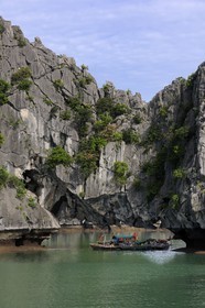 Vietnam, Quang Ninh Province, Halong Bay, listed as World Heritage by UNESCO, fishing boats under a naturel  limestone arch