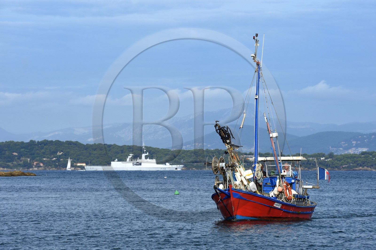 France, Var (83), Iles d'Hyères, parc national de Port Cros, Ile de Porquerolles, Bernard Samuel dit Sam le pêcheur sur son bateau, en arrière plan un navire de guerre en provenance de la rade de Toulon