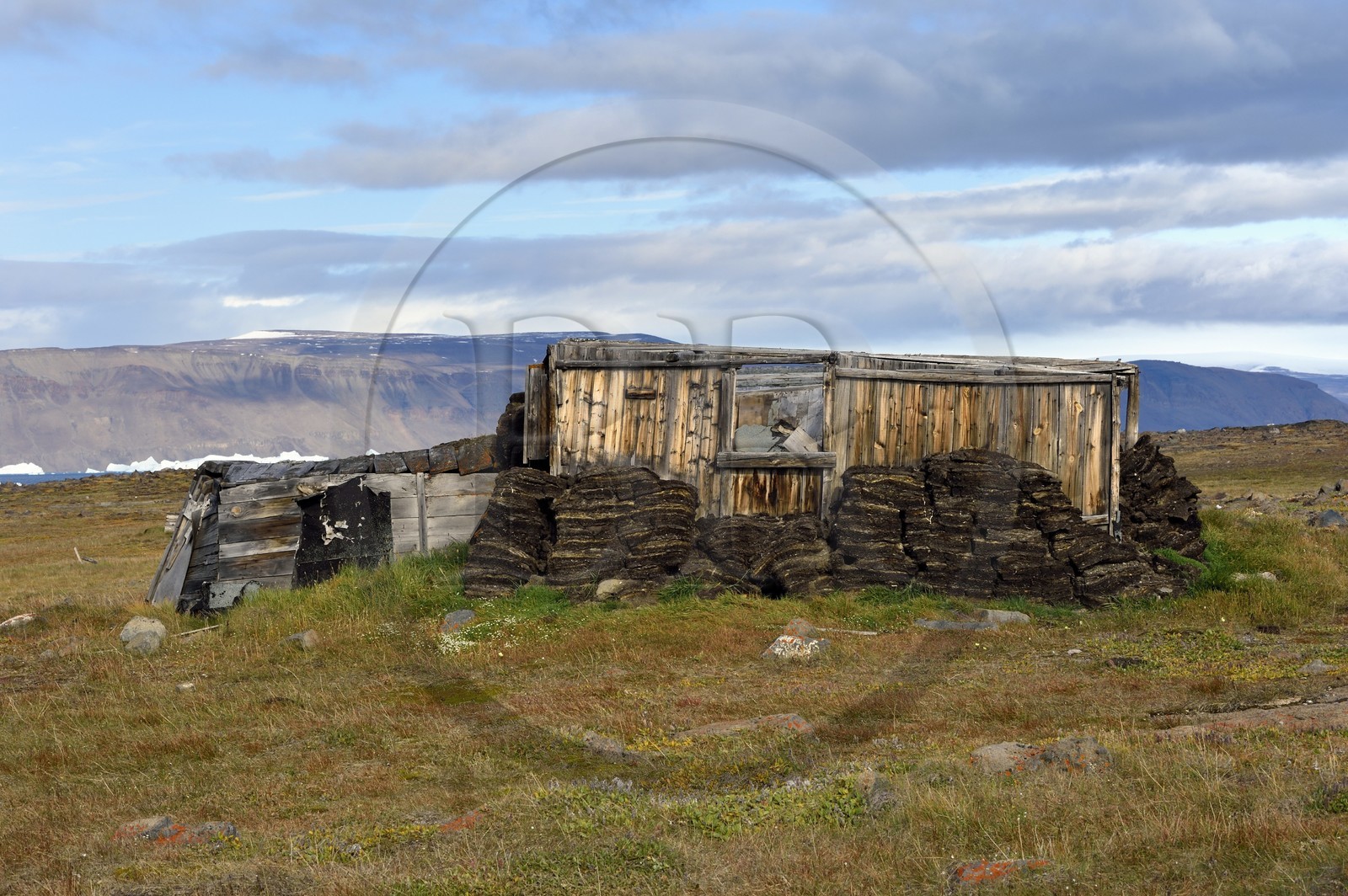 Groenland, cote ouest, Baie de North Star, Wolstenholme fjord, Dundas (Thulé), Igloo inuit, maison traditionnelle avec murs en tourbe et à partir du début du XXe siècle aussi une structure interne en bois, la calotte glaciaire en arrière plan